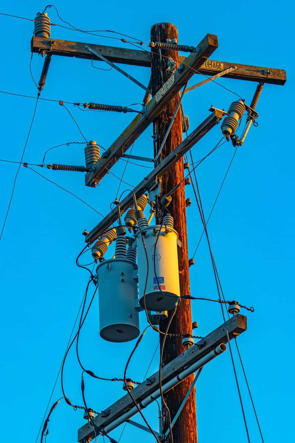 Pole mounted transformer against a blue sky