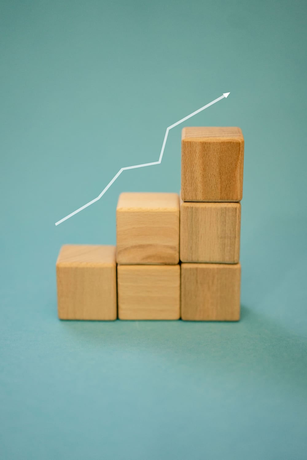 Wooden blocks forming rising steps with a growth arrow