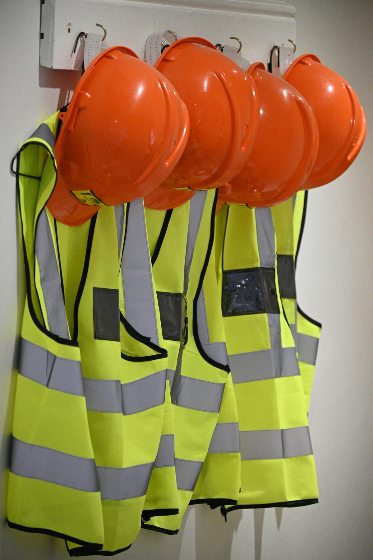 High visibility vests and safety helmets on a rack